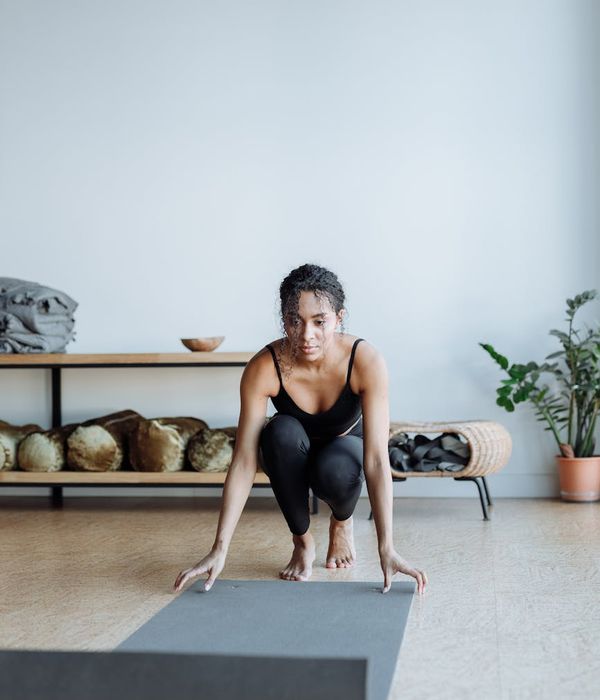 Person in a calm, mindful pose in a minimalist studio.
